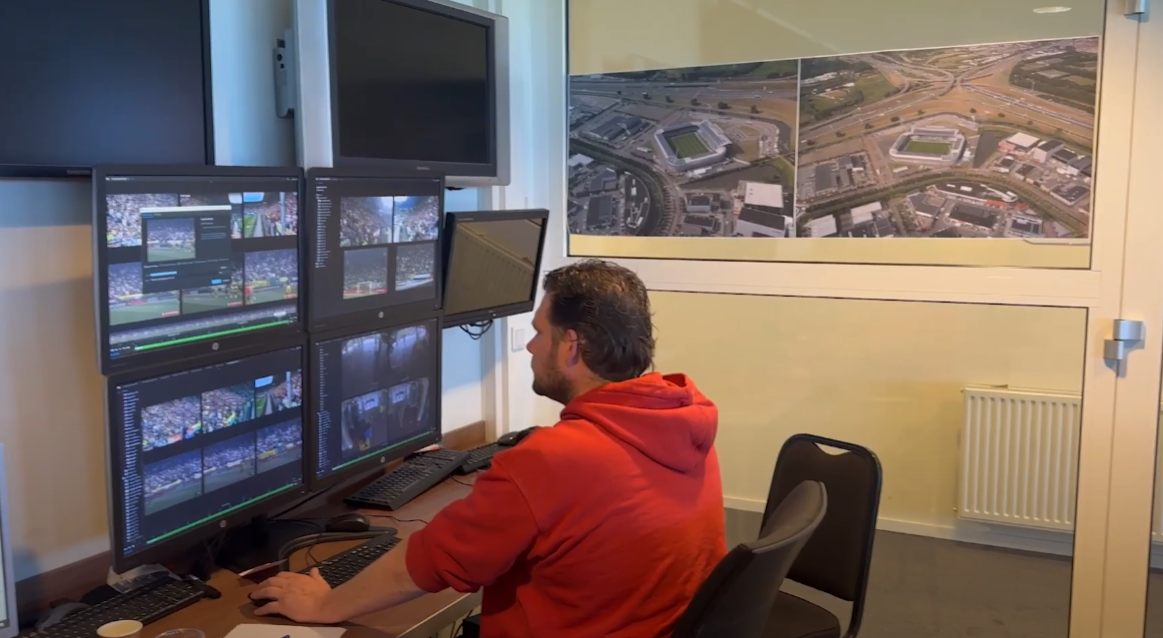 Centralist bekijkt live camerabeelden op meerdere schermen in een meldkamer.