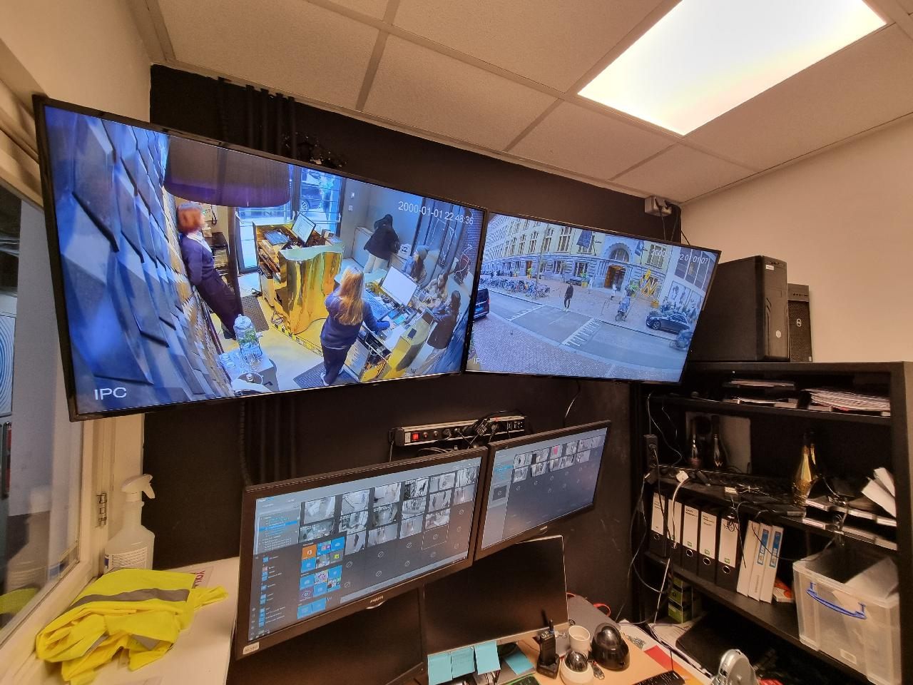 Meldkamer met live camerabeelden op meerdere schermen.