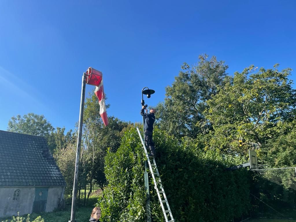 Monteur monteert een camera onder een overkapping.
