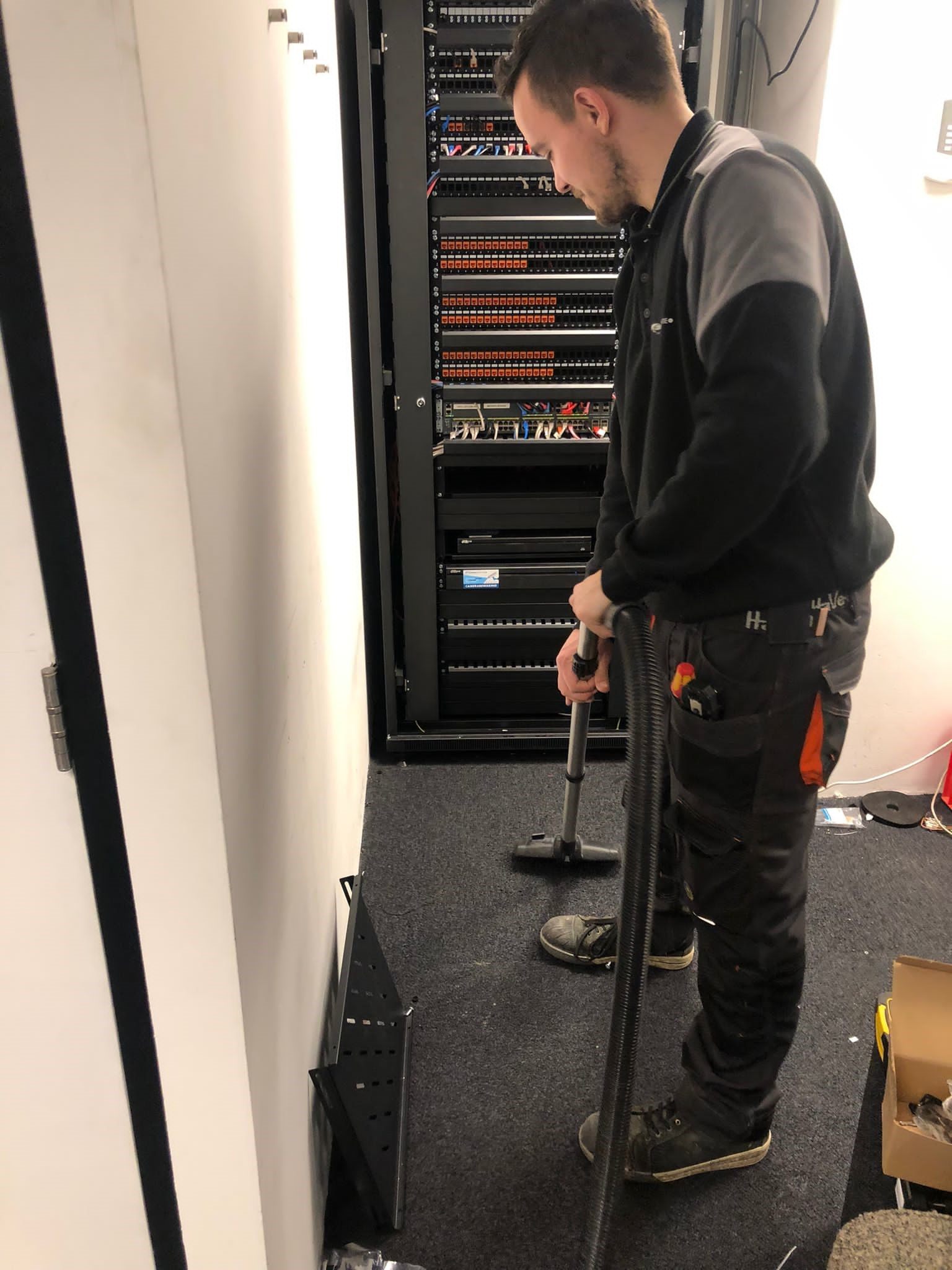 Monteur test de aansluitingen in een serverkast.