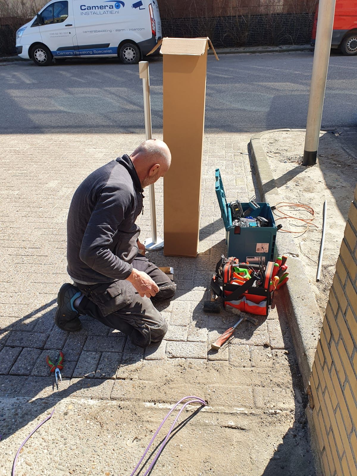 Monteur werkt aan de kabels in de voet van een buitenpaal.