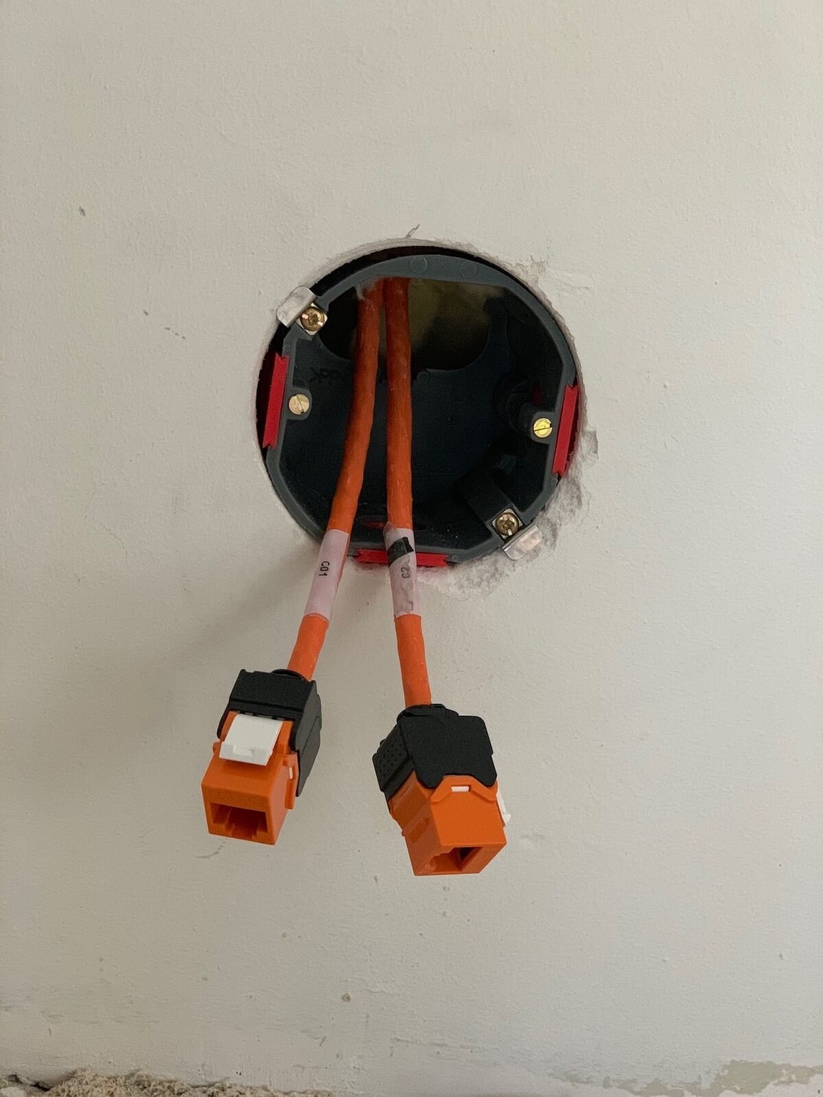 Inbouwdoos in de wand met twee oranje keystones, klaar voor afmontage.
