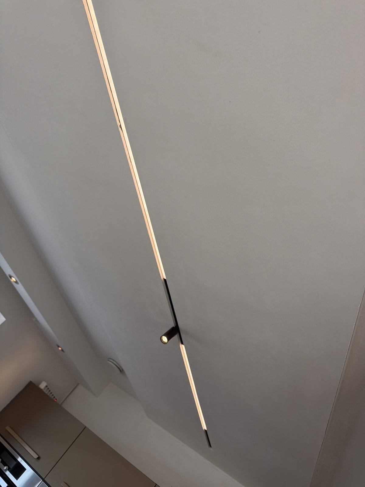 Inbouwrail met doorlopende lichtlijn en een richtbare spot boven de keuken.