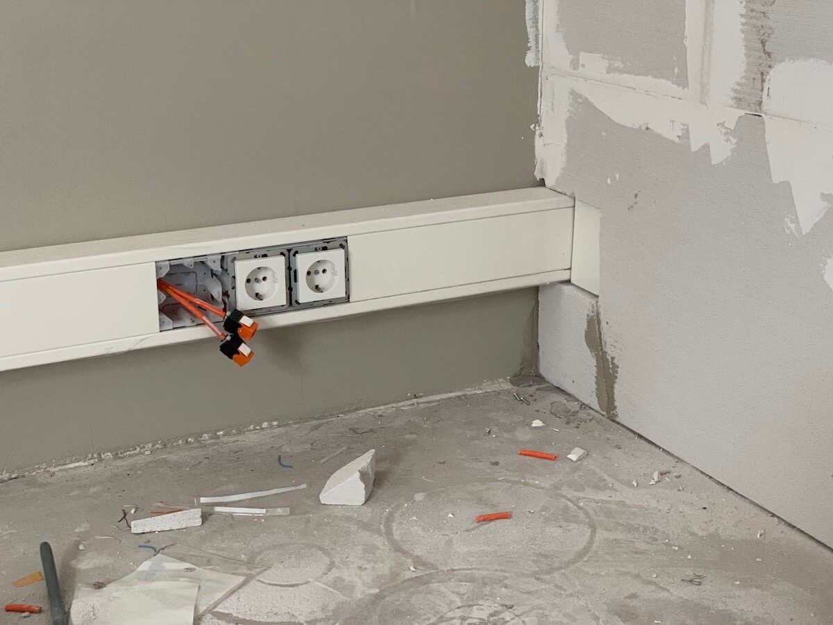 Kabelgoot die om de hoek doorloopt in een kantoor dat nog in afbouw is.