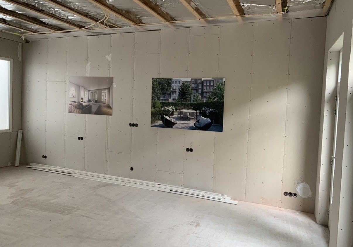 Woning in de ruwbouwfase: kale wanden met de inbouwdozen er al in, nog voor het stucwerk.